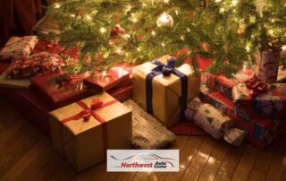 Image of presents under a Christmas Tree with the Northwest Auto Center Logo